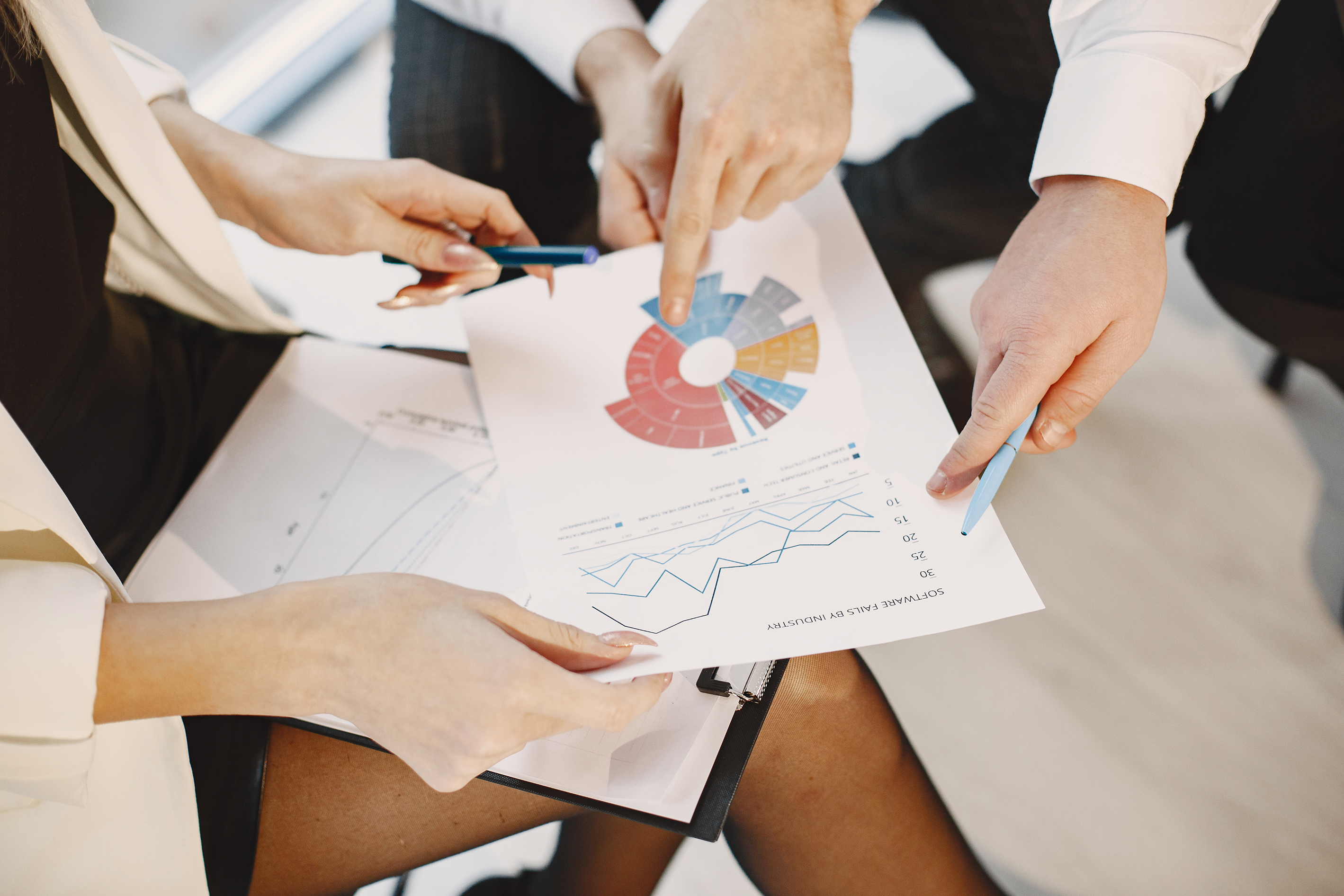 Background showing people discussing a project with chart statistics.